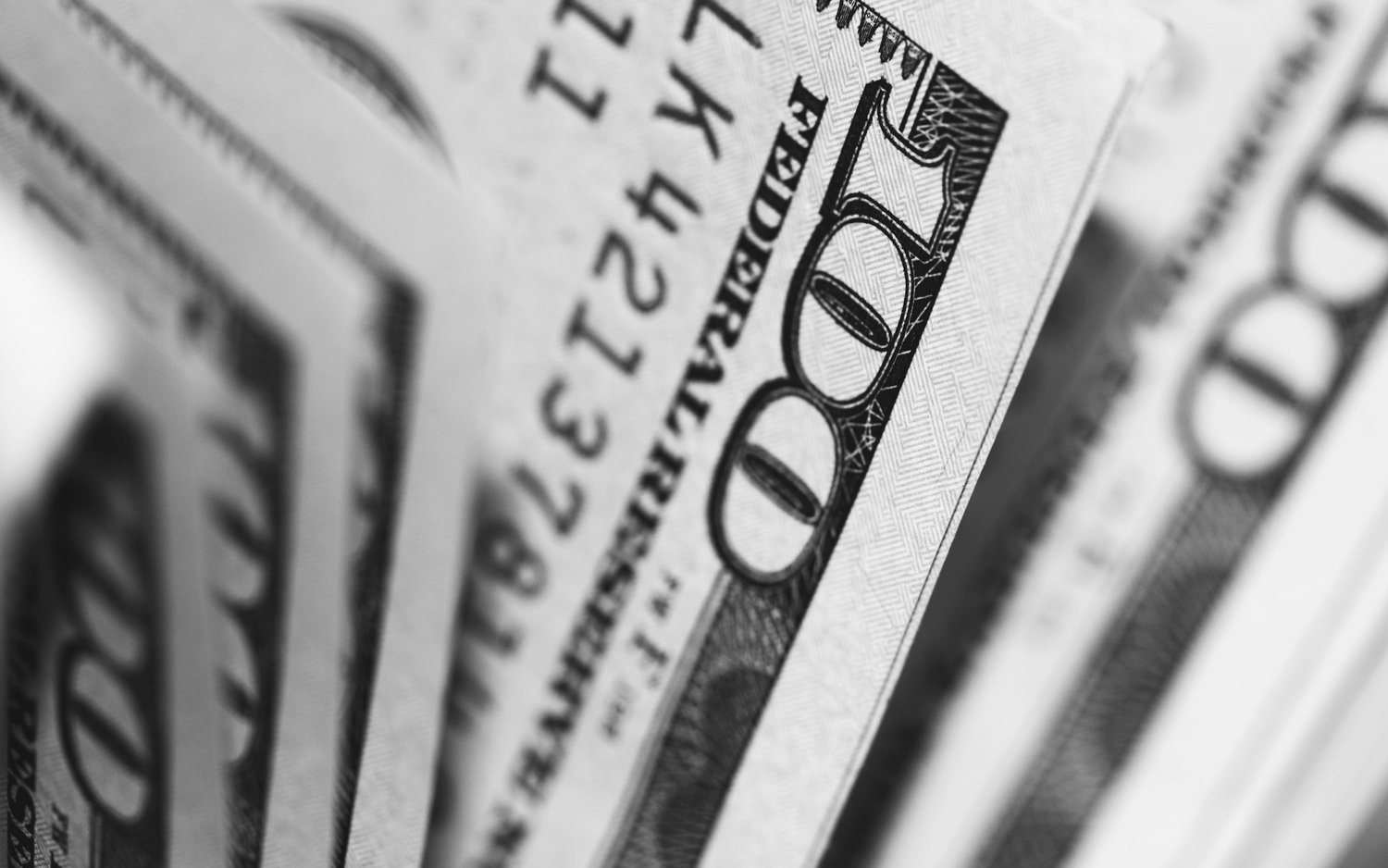 Black and white close-up of fanned one hundred dollar bills