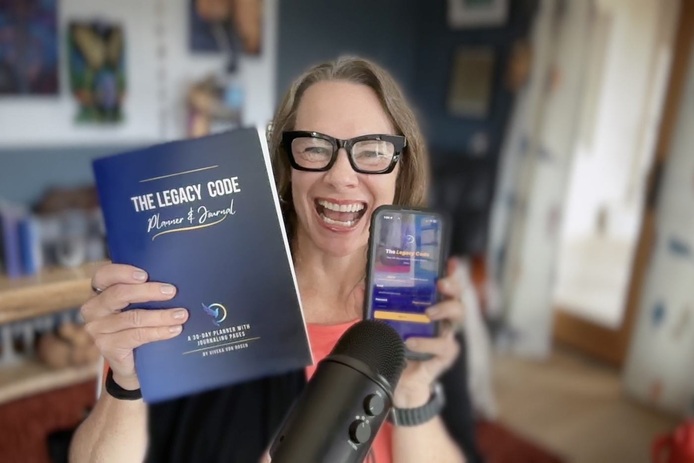 Viveka von Rosen holding the printed Legacy Code journal and the app version on her phone